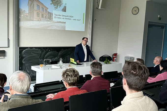 Der Rektor hält einen Vortrag im besetzten Vorlesungssaal.