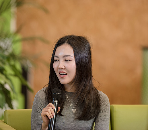 Kasachische Studentin mit Mikro auf dem Talk-Sofa
